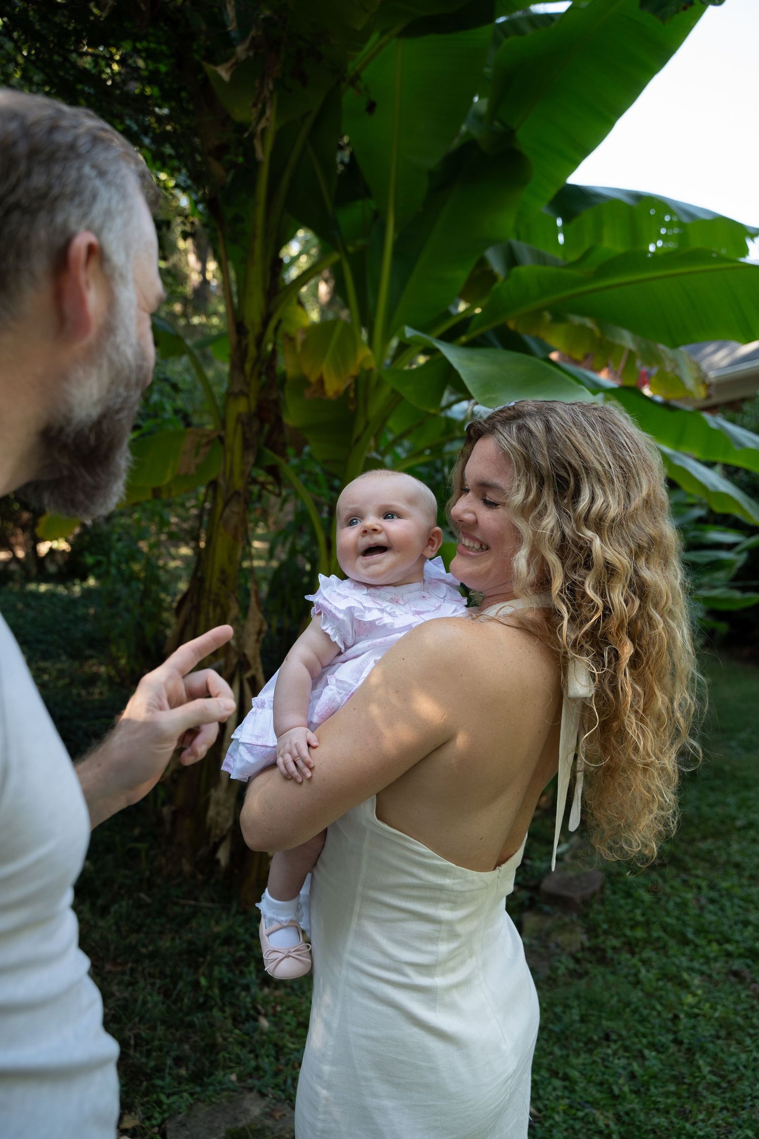 Series of candid moments in a lush garden setting with banana plants. Charlotte photographer. Charlotte family photographer.
