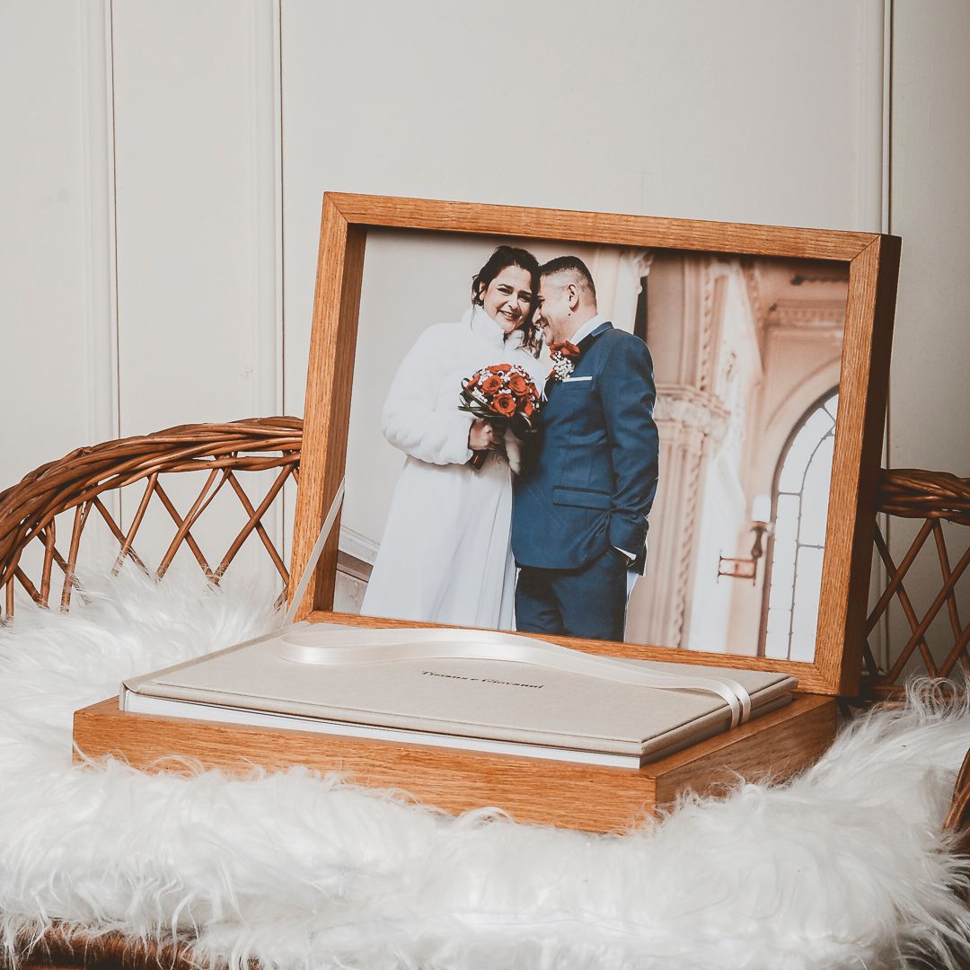 A framed wedding photo displayed with a wooden keepsake box on white fur.