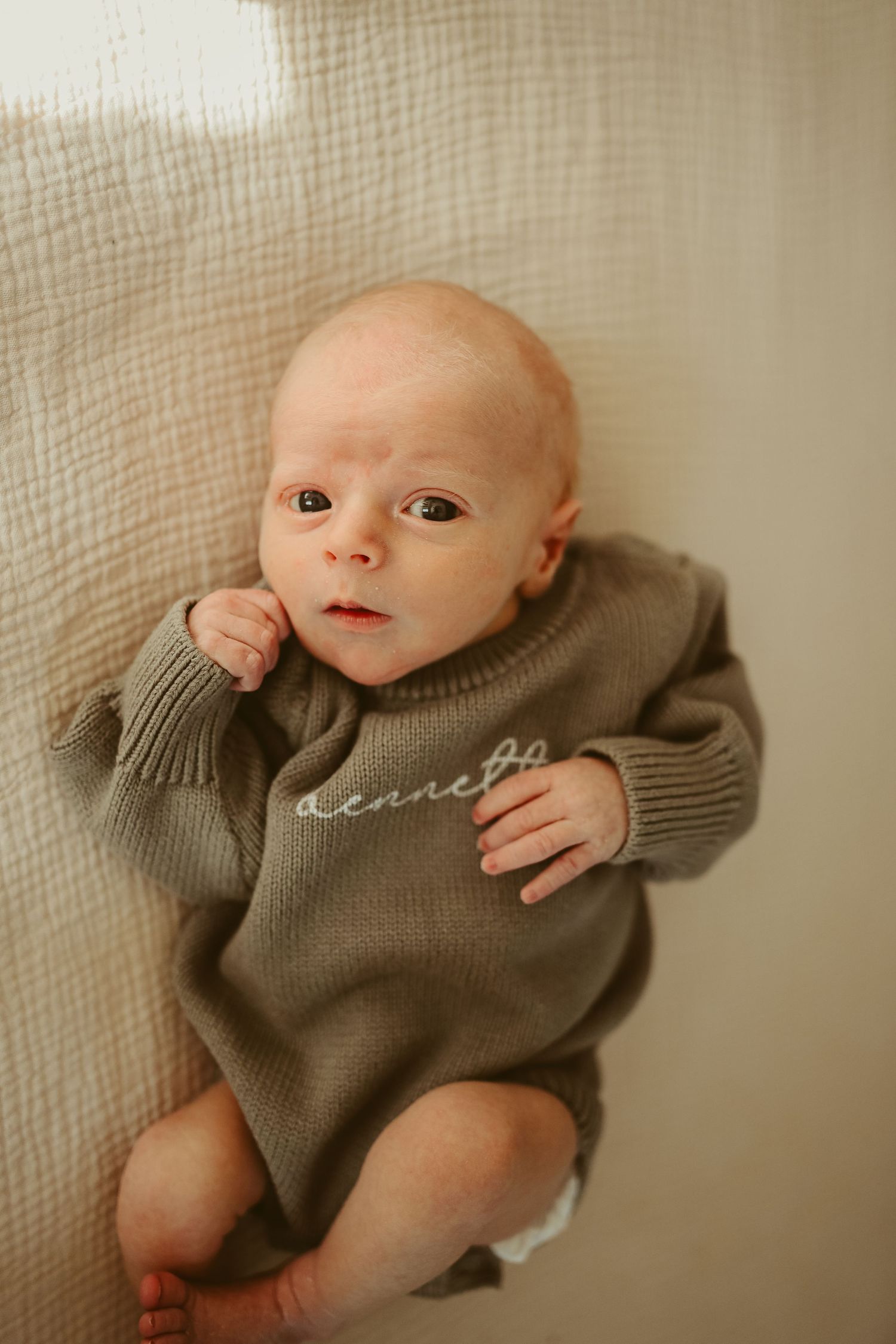 Baby boy looks at camera during lifestyle newborn session in Clarksville, Tennessee by Disney Magic Photography