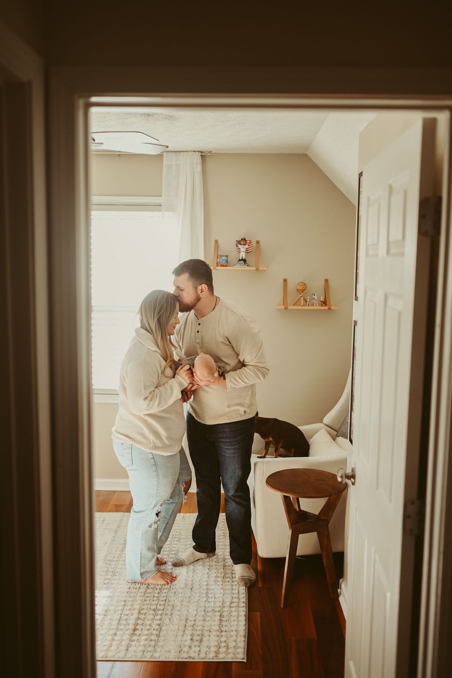 Through the doorframe, a unique shot is captured during lifestyle newborn session in Clarksville, Tennessee by Disney Magic Photography