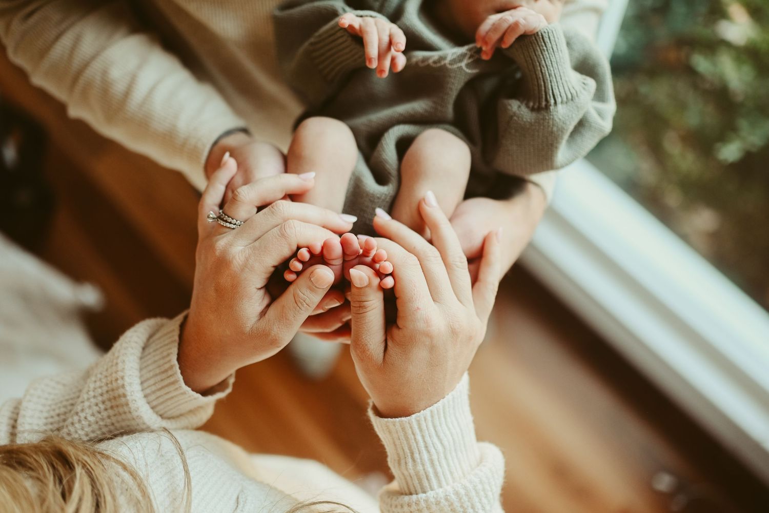 Ten little tiny toes are shown off between mom and dad's hands during lifestyle newborn session in Clarksville, Tennessee