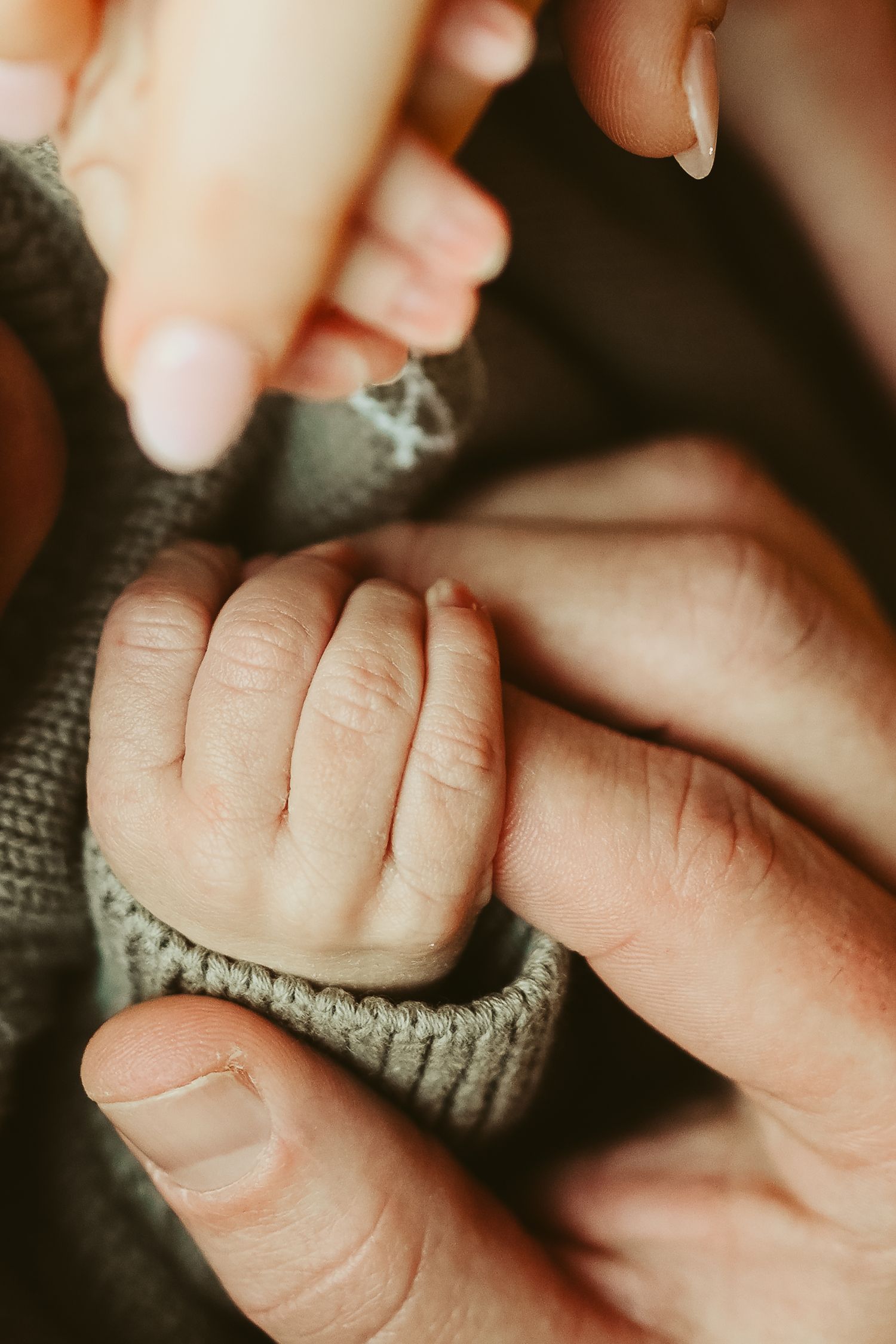 Tiny baby fingers being embraced by mom and dad during lifestyle newborn session in Clarksville, Tennessee by Disney Magic Photography