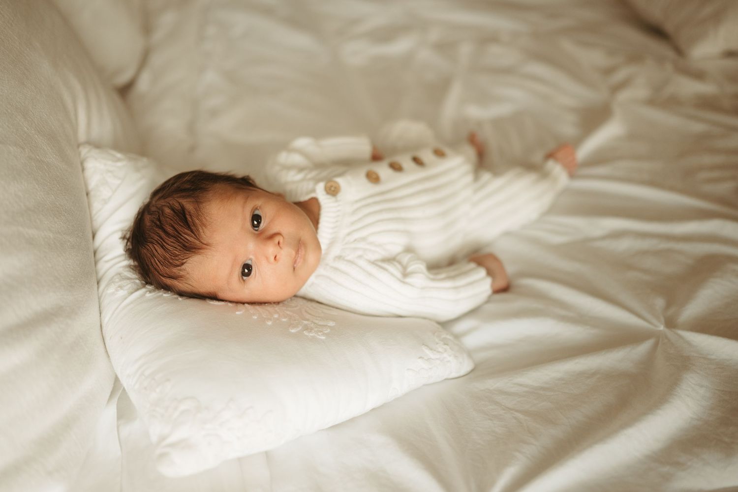 Baby boy looks into camera during lifestyle newborn session in Clarksville, Tennessee by Disney Magic Photography
