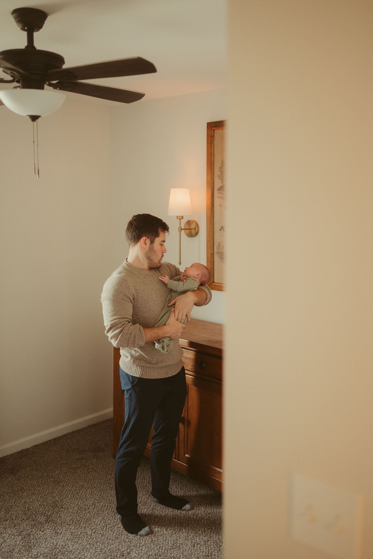 Dad rocks baby in nursery during lifestyle newborn session in Clarksville, Tennessee by Disney Magic Photography
