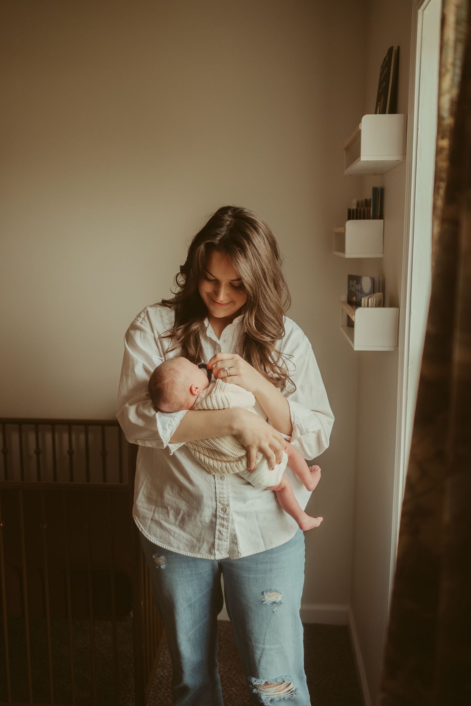 Mom looks lovingly at baby boy during lifestyle newborn session in Clarksville, Tennessee by Disney Magic Photography
