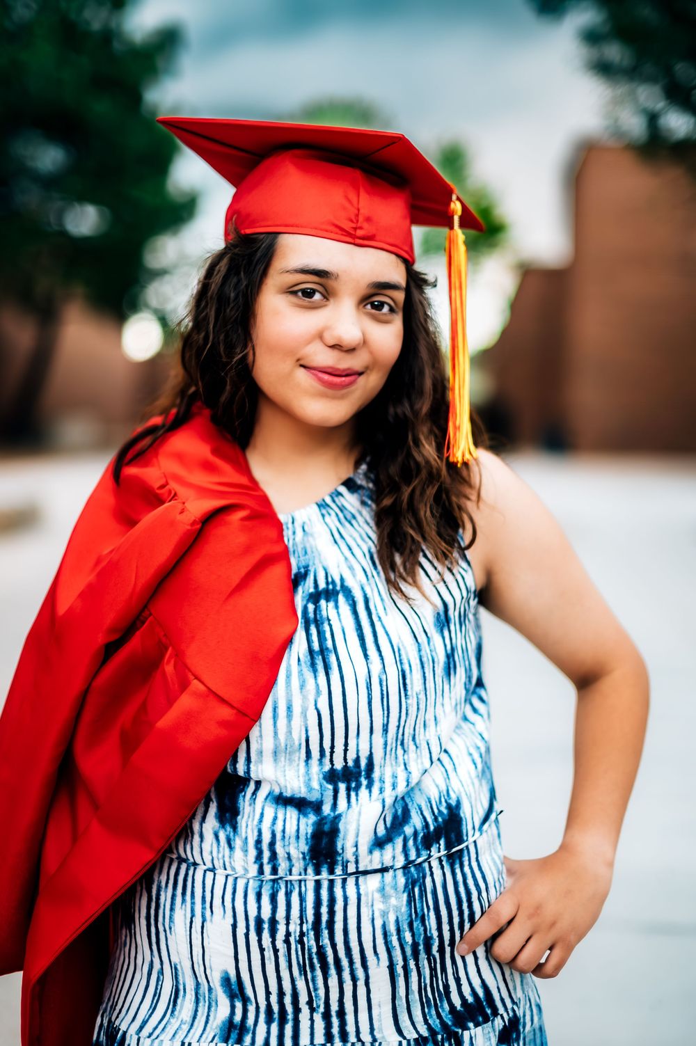 Senior graduation photos featuring student in red cap and striped dress.
