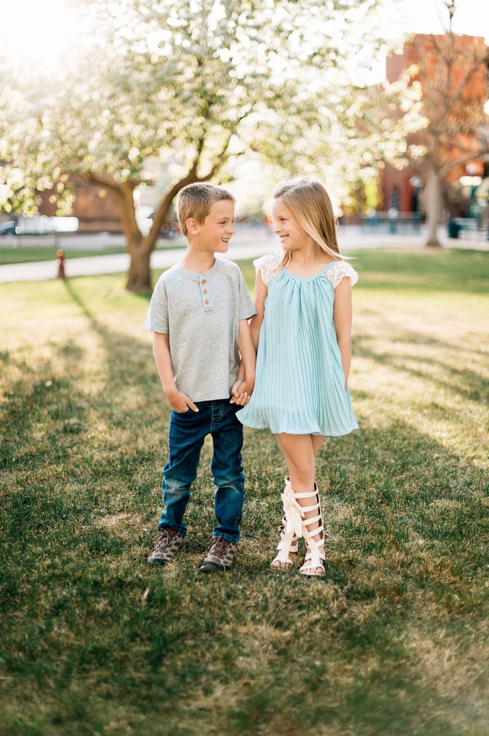 Spring outdoor scene with coordinating blue and mint outfits under blooming trees.