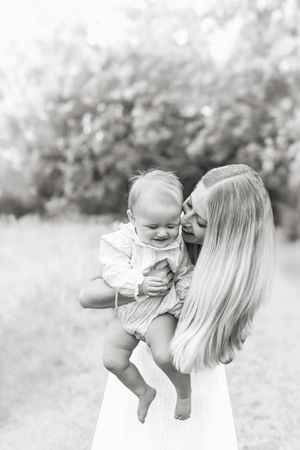 A series of black and white photos showing tender moments between a parent and child outdoors in nature in Ventura Iowa.