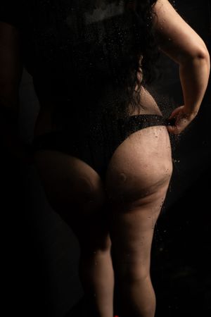 Silhouetted figure against dark background with water droplets.