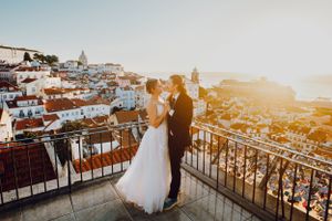 Elopement Couple photo with a view of Lisbon's cityscape from a scenic viewpoint balcony in Alfama.