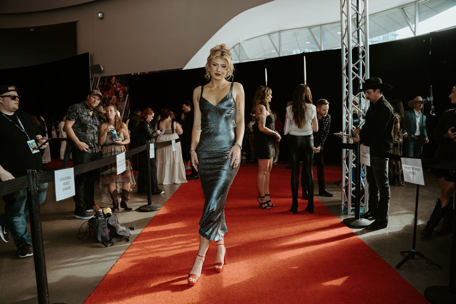 Dasha walks confidently down a red carpet runway during CCMA event.