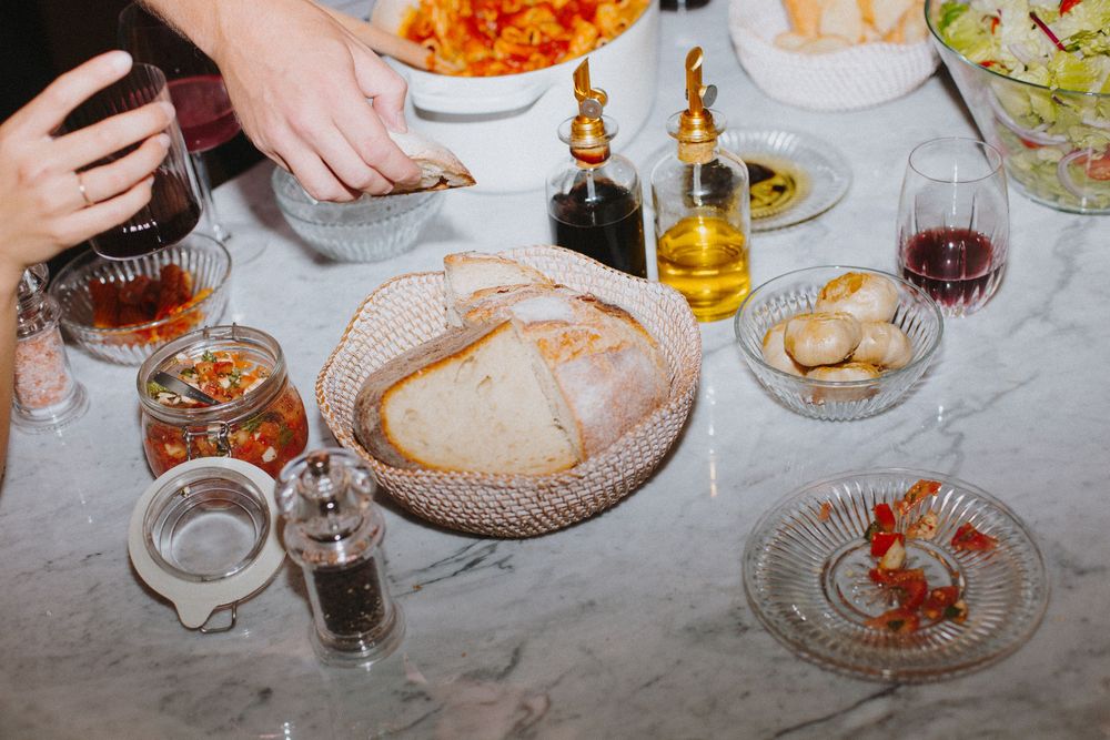 Overhead view of a dinner table with colorful dishes, drinks, and shared plates.