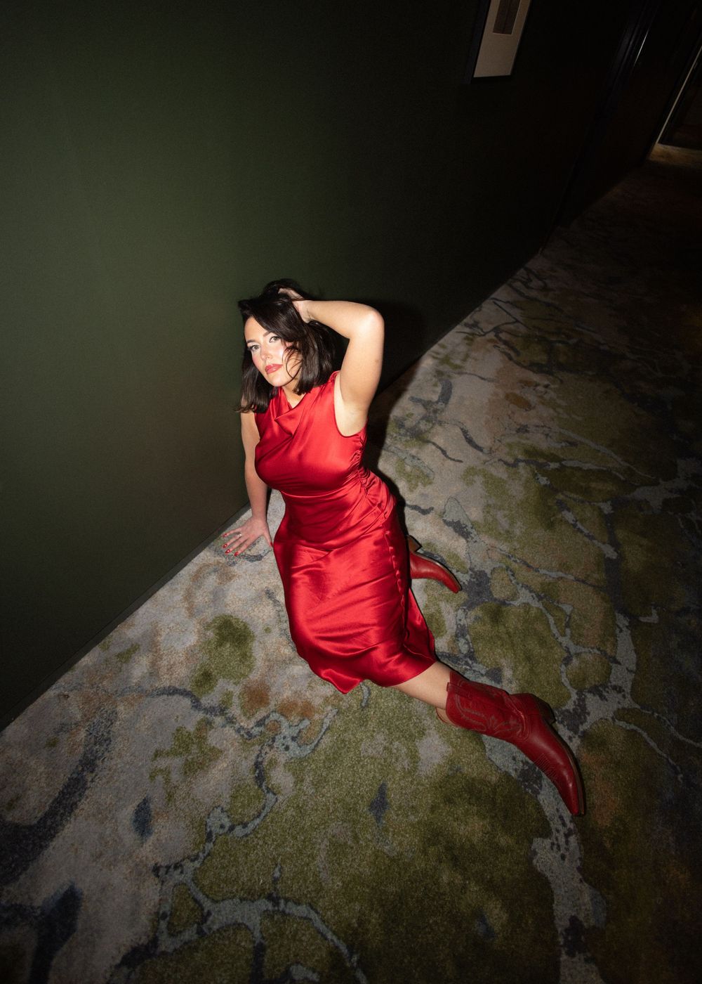 Dynamic shot of person in red dress against dark background with dramatic lighting.