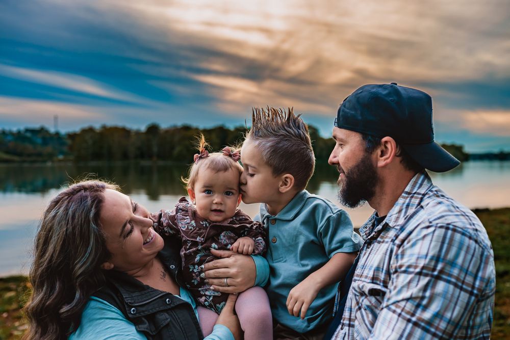 A family shares tender moments together by a lake during sunset in a series of connected lifestyle photos.