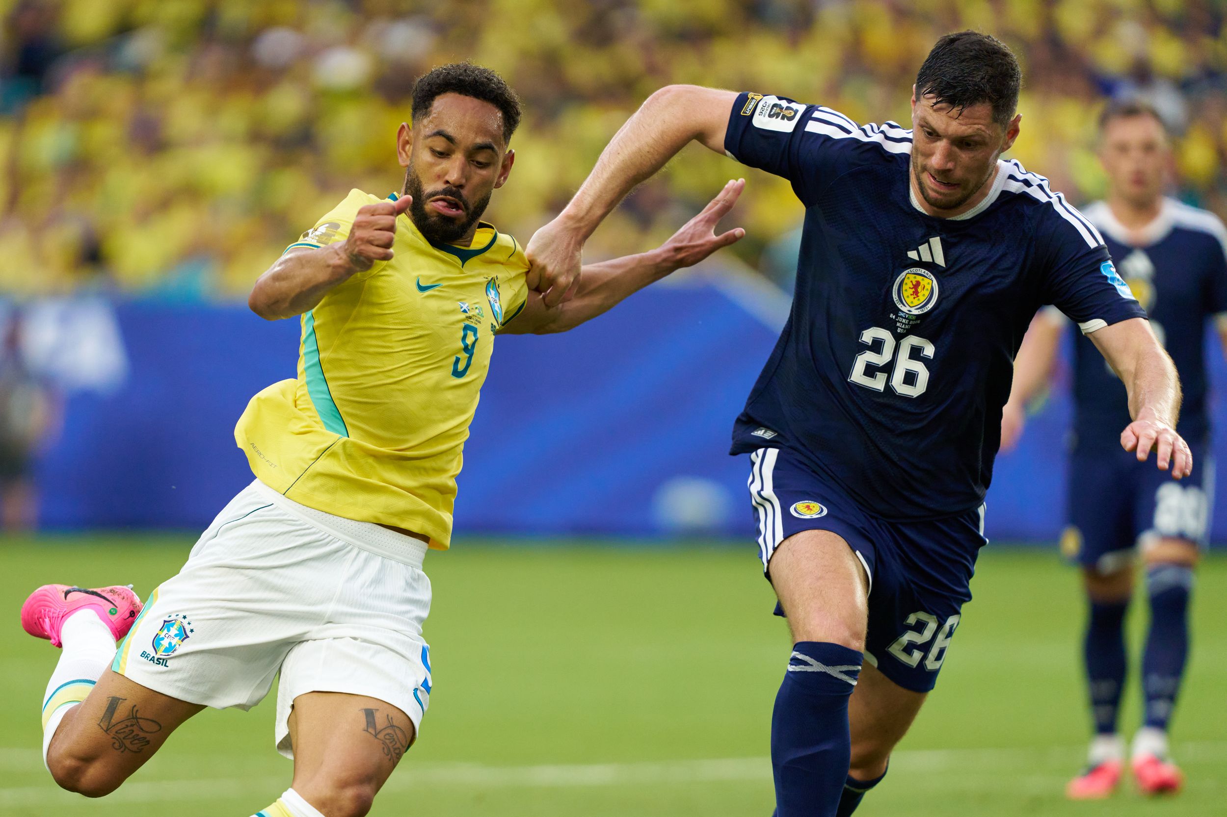 Brazil vs Scotland football match with players competing for the ball, Brazil in yellow and Scotland in dark blue jerseys.