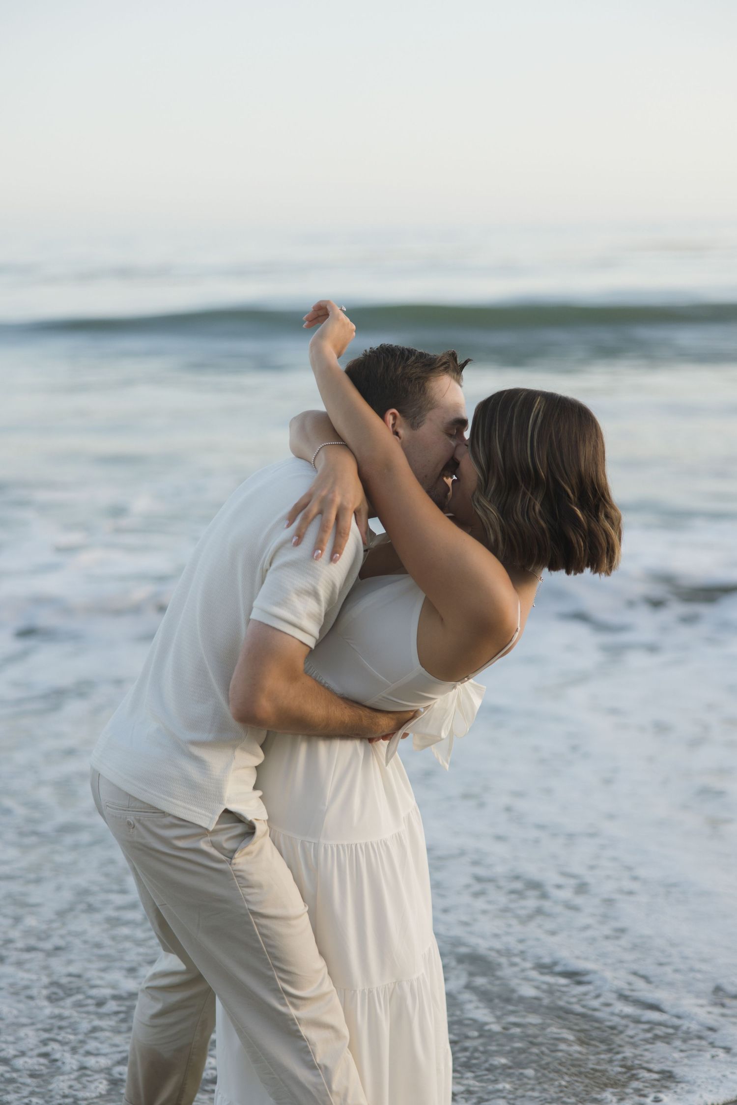 Engagement photos of a couple kissing in the ocean at El Matador Beach in Malibu, California