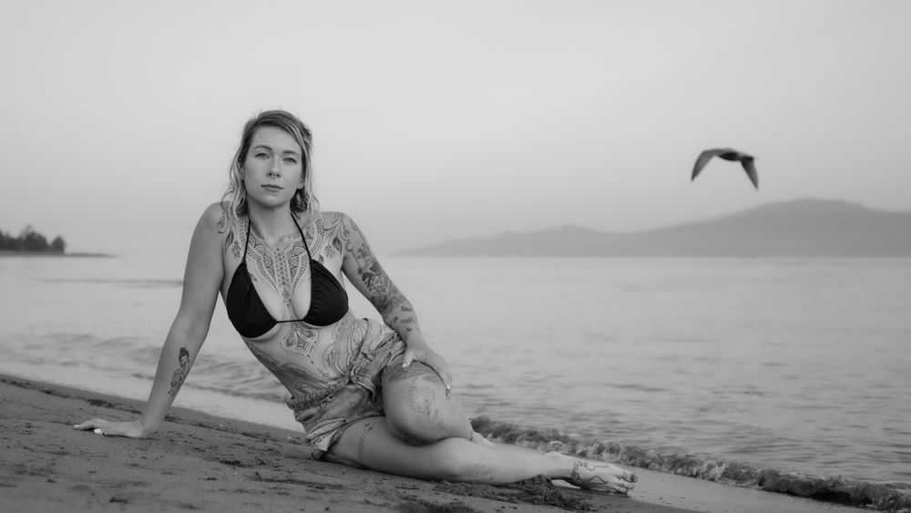Black and white portrait of woman sitting on beach, North Vancouver photographer