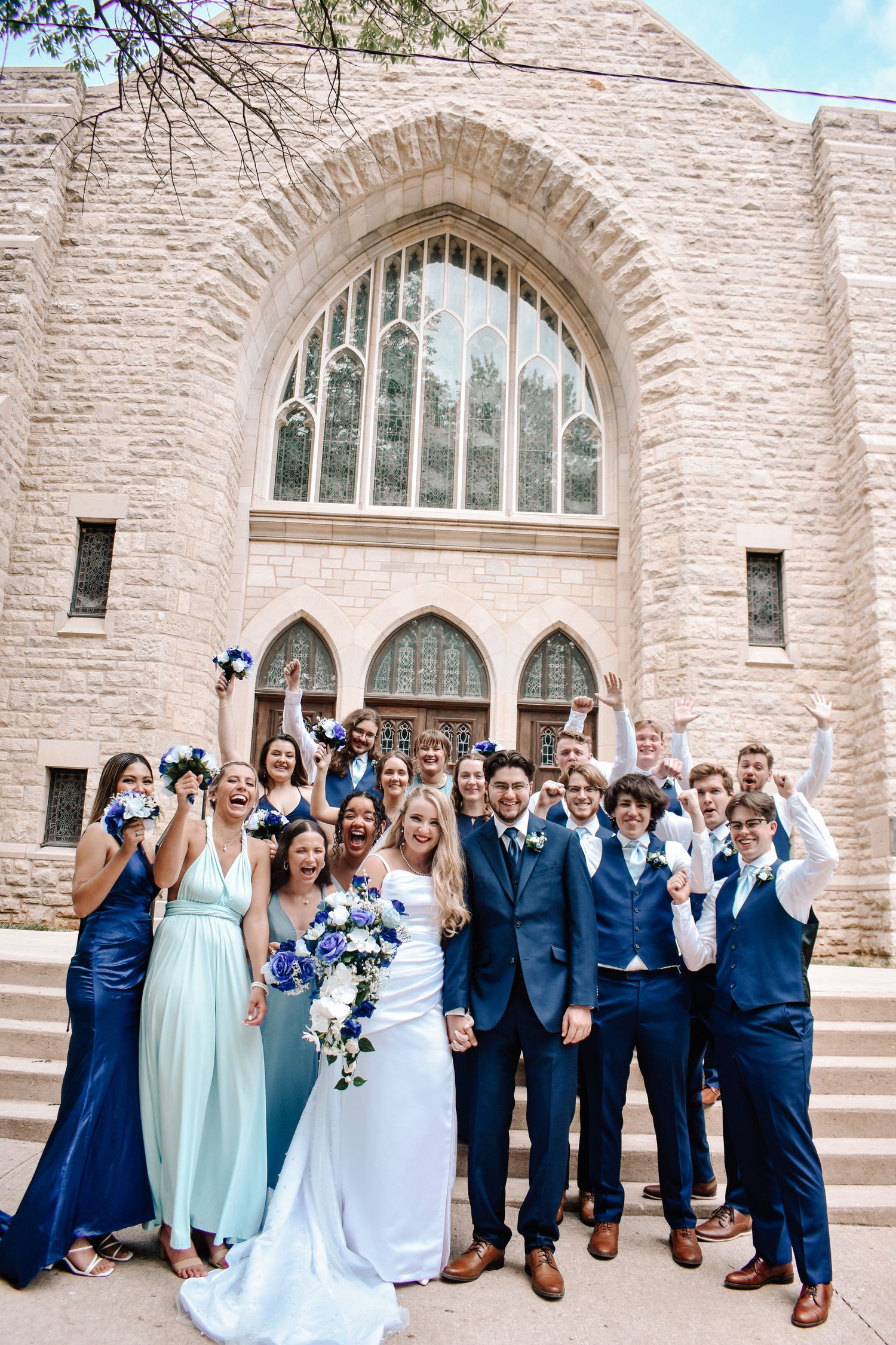 wedding party celebrates in front of church