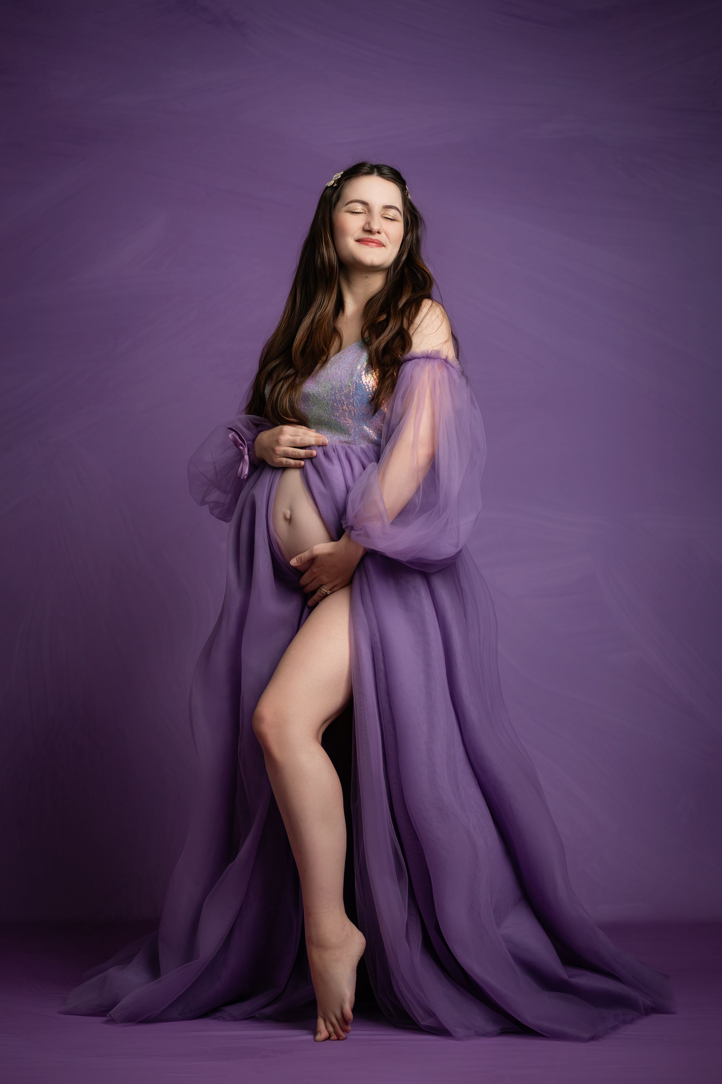 Artistic boudoir photo series featuring a figure draped in flowing purple fabric against a dark purple backdrop.