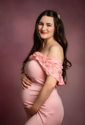 Maternity photo series showing a pregnant person in a pink dress against a burgundy background in different elegant poses.