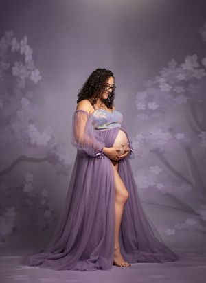 A maternity photoshoot sequence showing a flowing purple gown against a dreamy purple-tinted backdrop.
