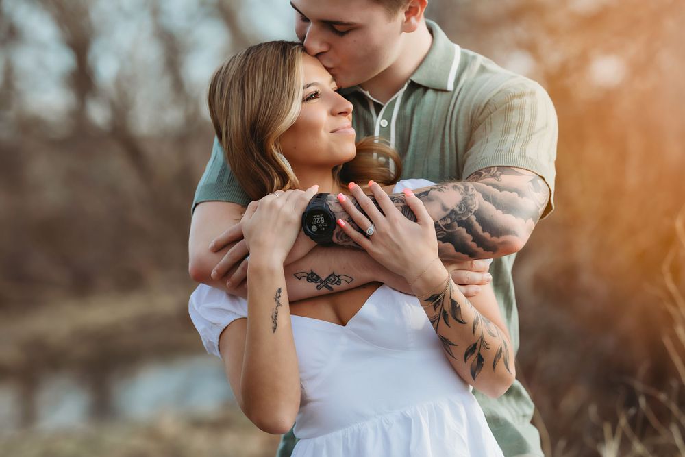 Romantic outdoor couple embrace in warm sunset lighting for gorgeous engagement photo