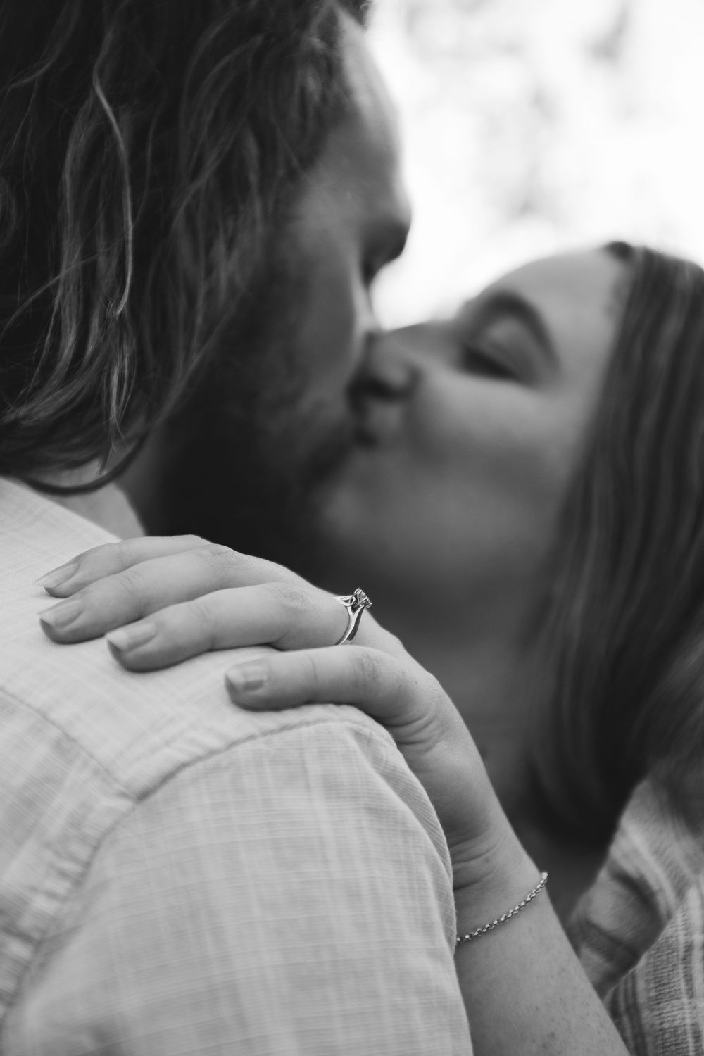 Couple Kissing, focus is on the engagement ring