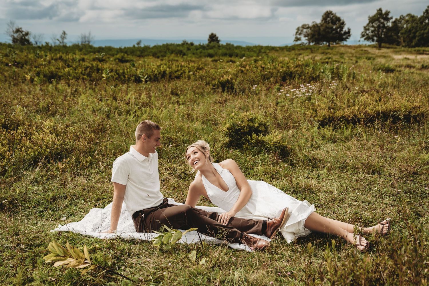 Romantic proposal moment captured on mountain overlook with sweeping valley views.