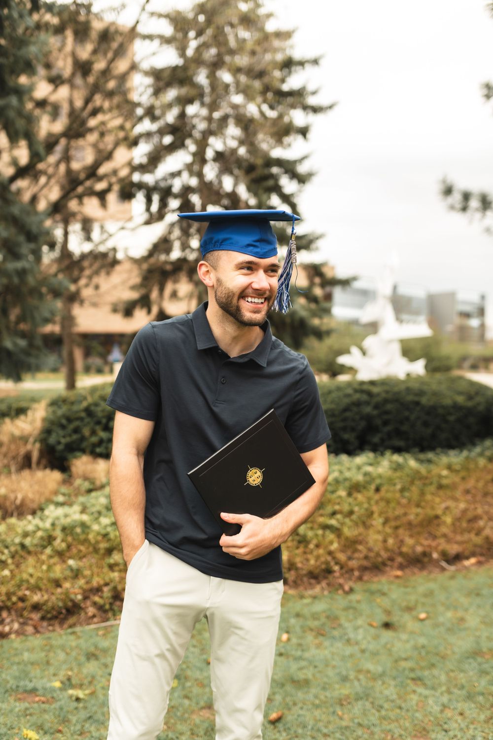 Graduation portrait of a Grand Valley graduate with is cap and diploma.
