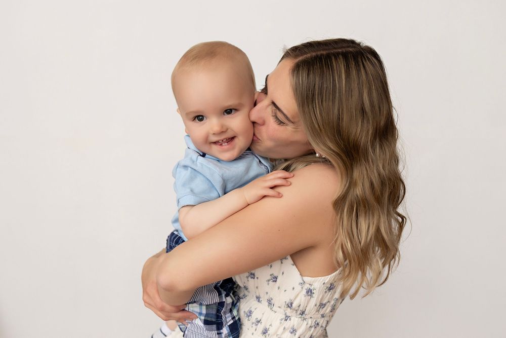 A tender moment captured between parent and baby in soft, natural light against a light backdrop.  Kendall Kuss Photography Watertown WI