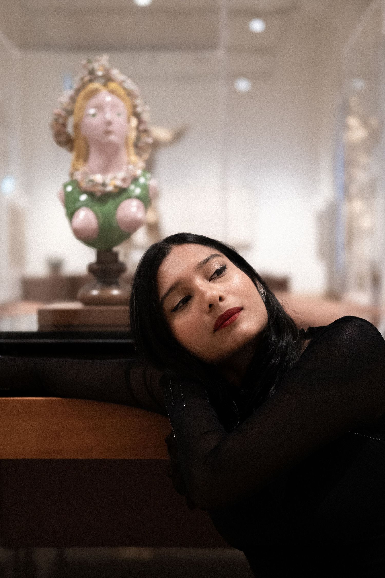 Artistic portrait series against blurred background with decorative busts.