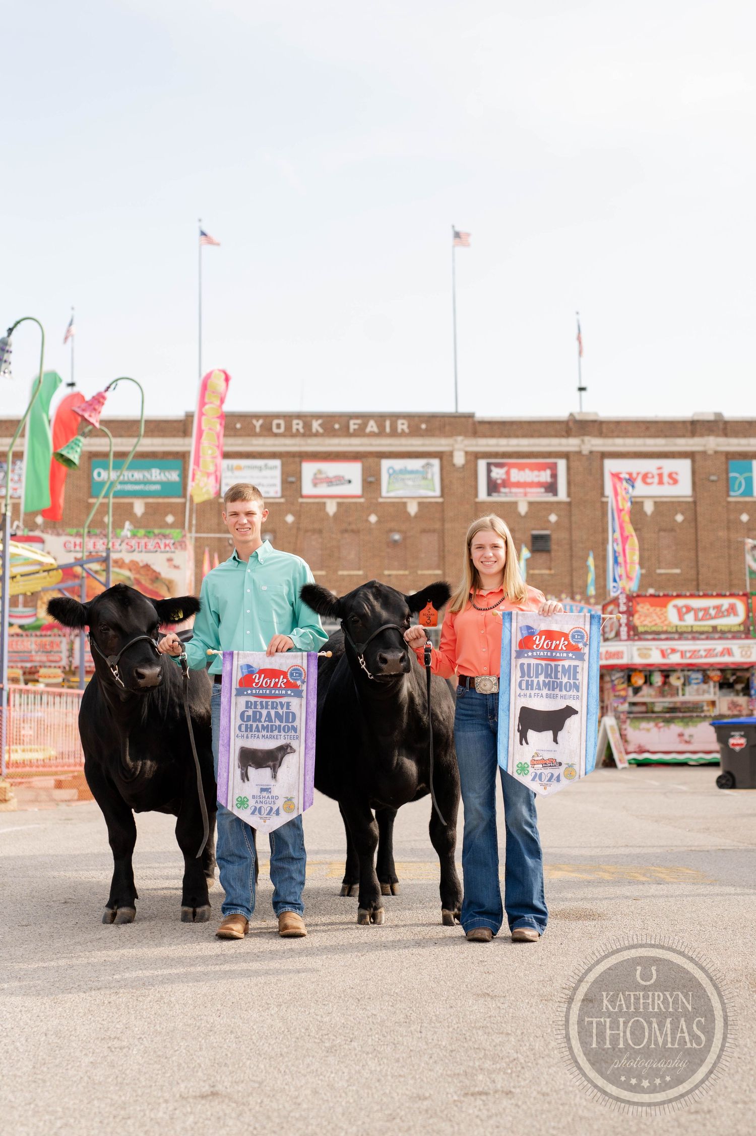 Award-winning black cattle on display with their handlers at the York State Fair.