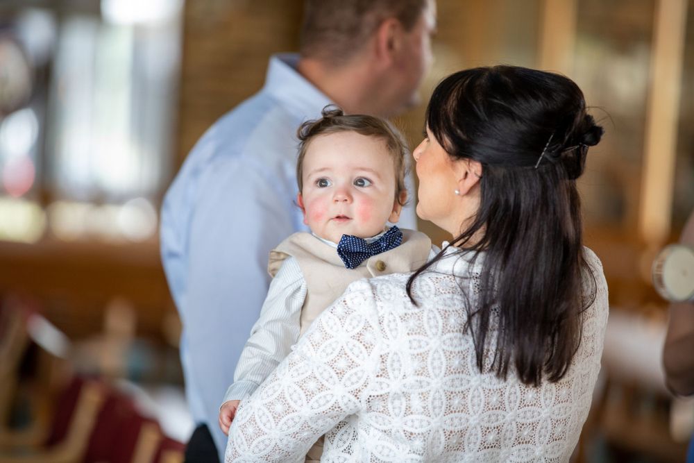 baby boy getting christened with mother holding him
