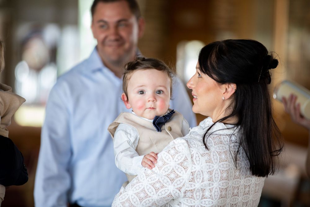 baby boy getting christened with mother holding him