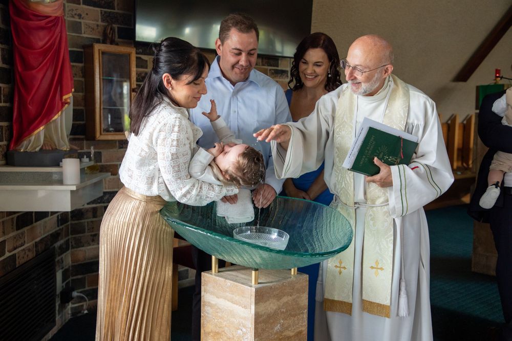 baby boy getting christened with mother holding him