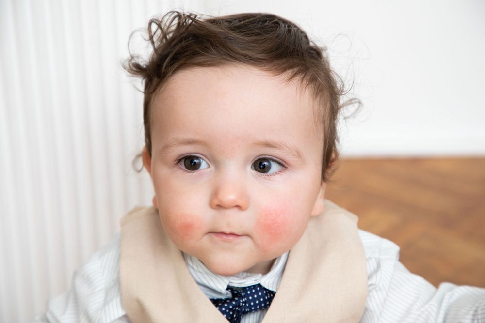 baby boy getting christened with mother holding him