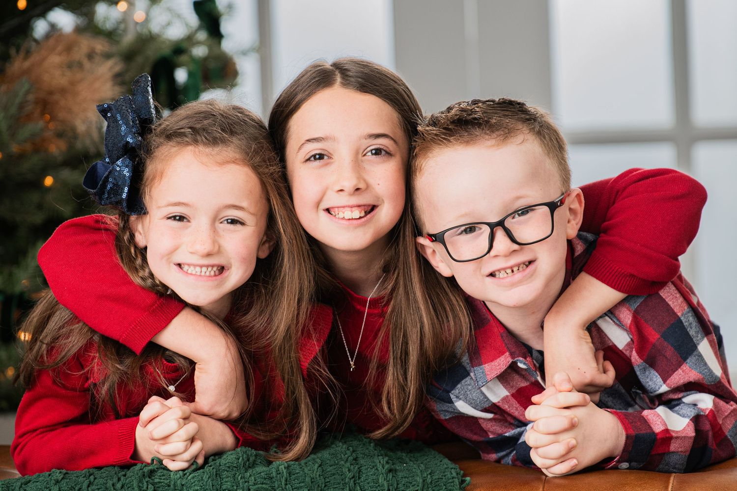 Siblings hugging each other in the studio, capturing a heartwarming moment together for the holiday season.