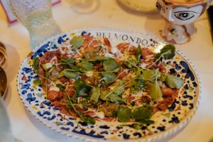 A fresh green salad with colorful toppings served on a decorative blue and white patterned plate.