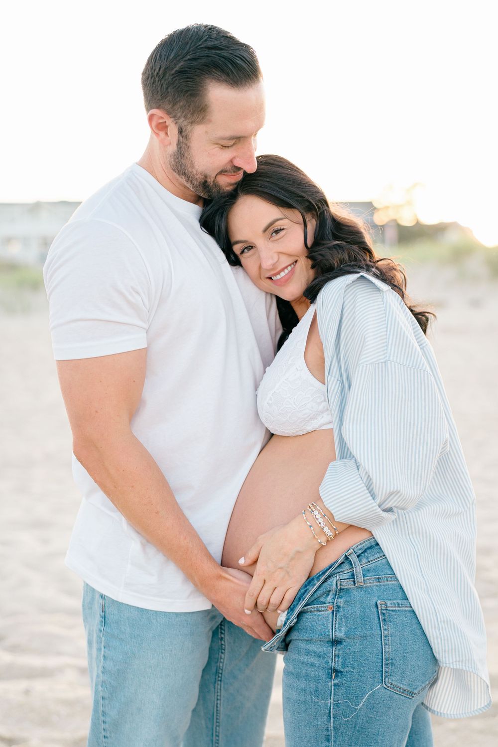A couple hugs on the beach at sunset in Monmouth County New Jersey.