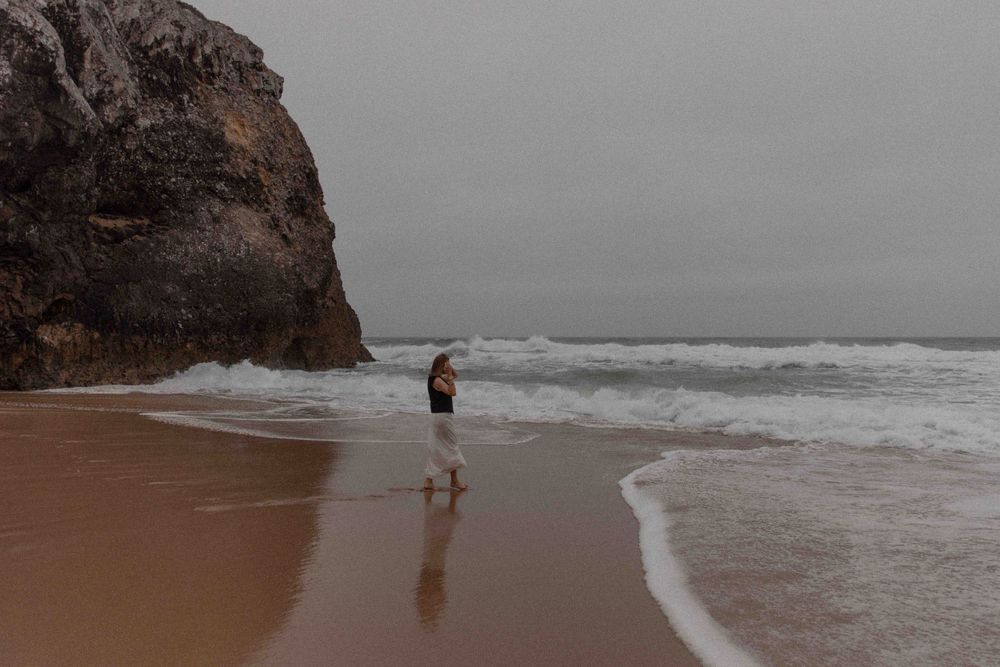 Moody seascape with cliffs and waves on an overcast beach day.