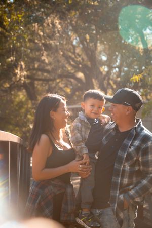 A family shares a joyful moment together outdoors on a sunny autumn day.