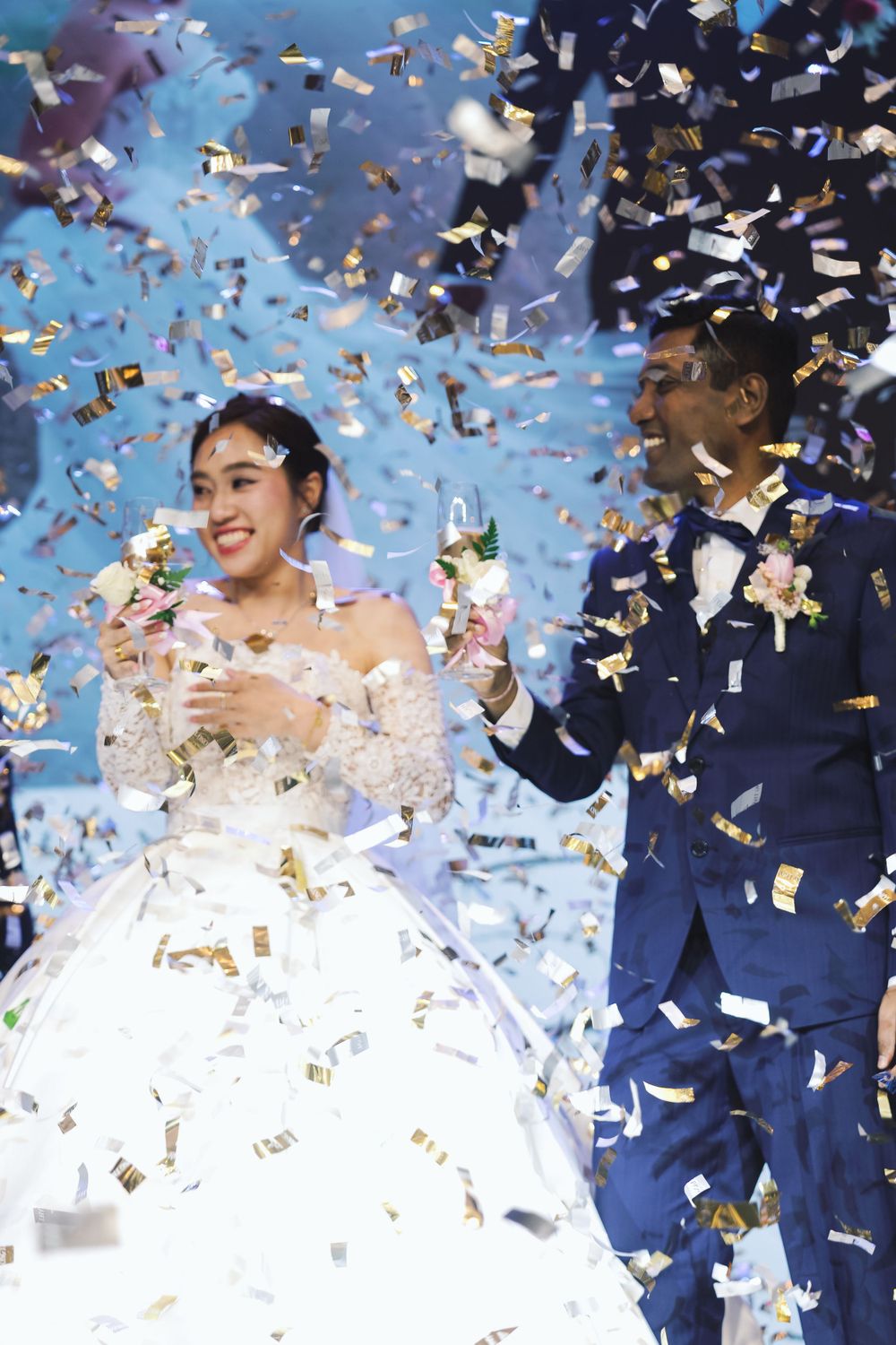 Joyous wedding celebration moment with confetti raining down on couple.