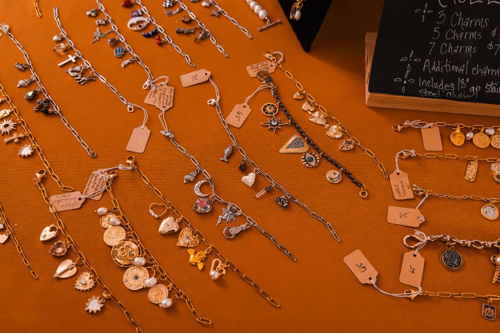 Decorative display of vintage keys and charms hanging on orange background.