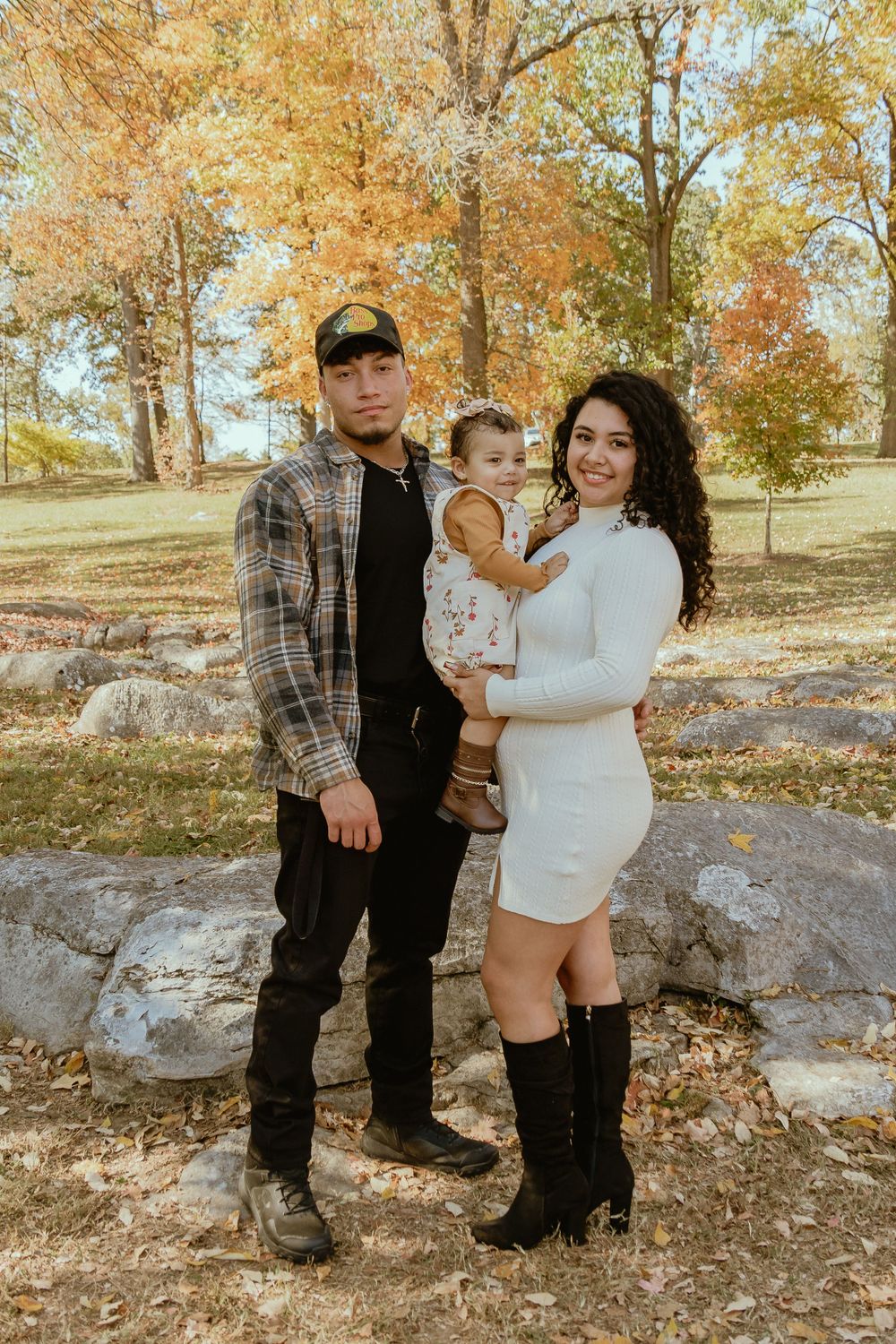 Family portrait in autumn setting with fall foliage and warm tones.