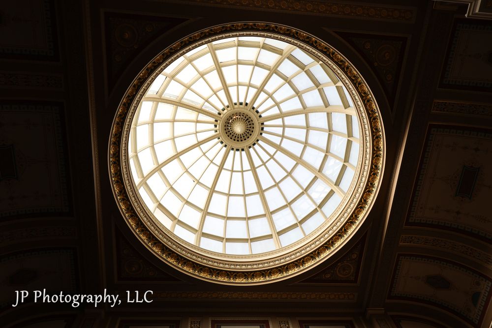 Circular glass skylight dome with geometric patterns casting natural light from above.