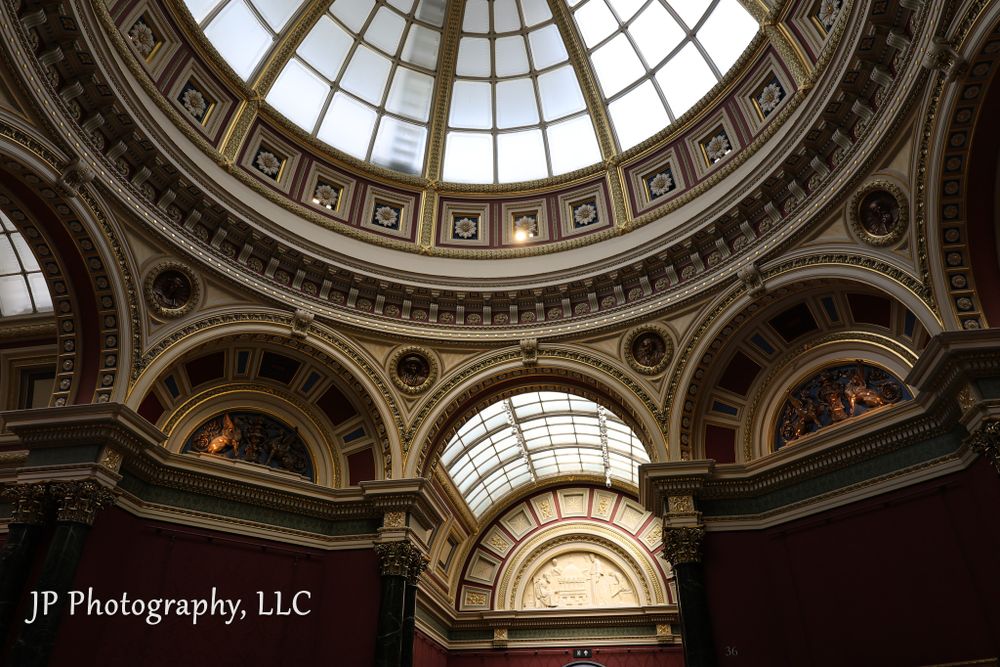 Elaborate Victorian glass dome ceiling with decorative moldings in classical architecture.