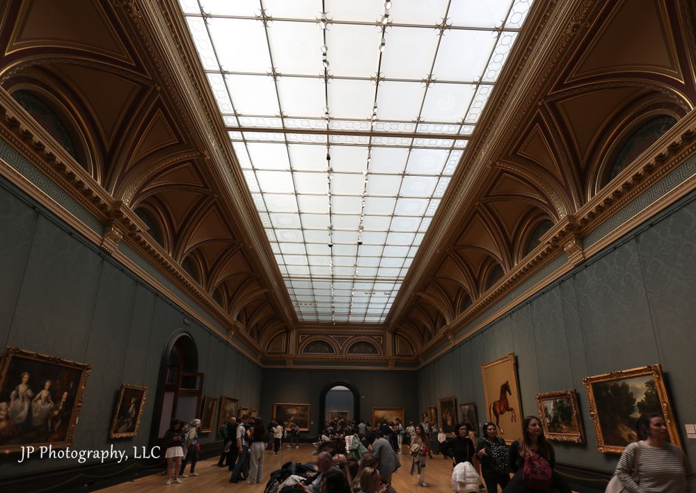 Panoramic view of a grand museum gallery with skylights and classical architectural elements.