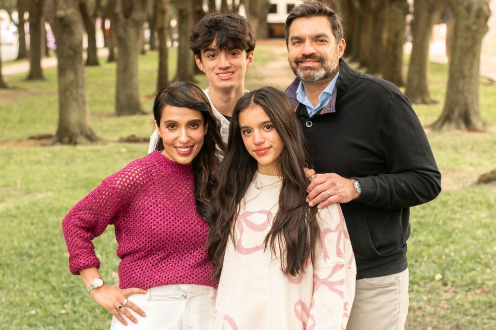 Group portrait of four people outdoors wearing coordinated casual outfits among trees.