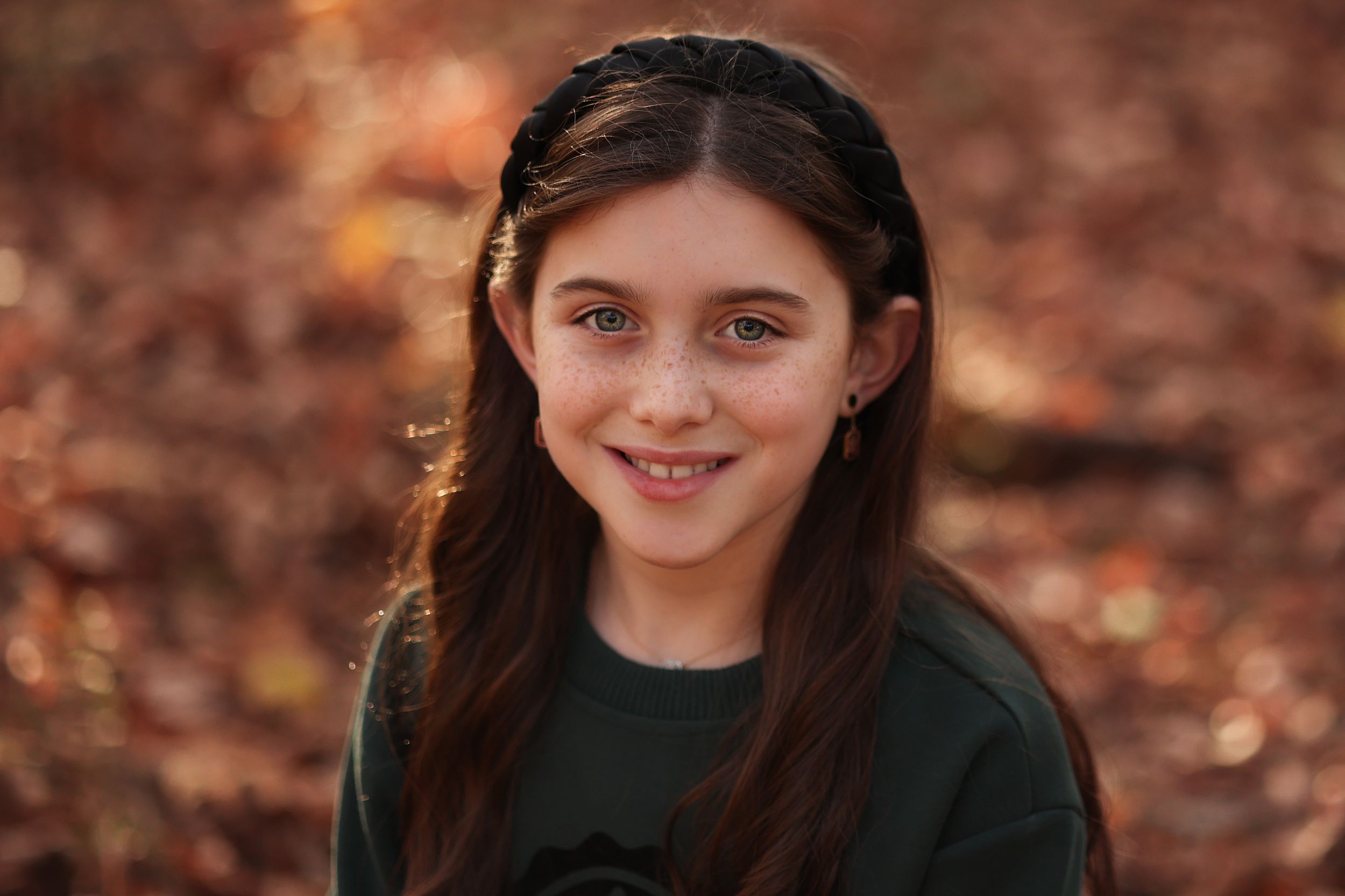 on-location close-up portrait of a smiling 12 year old girl