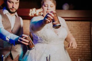 Bride and groom mixing cocktails together behind the bar at their wedding reception.